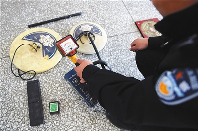民警展示盜墓團伙使用的金屬探測儀。圖/新華社